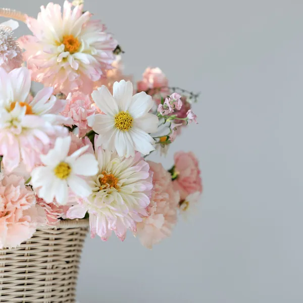 Pale pink flowers in a woven basket