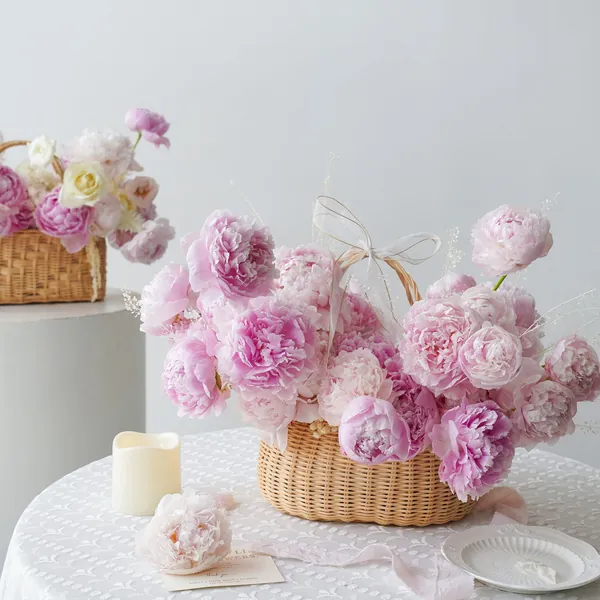 Pink and white peonies in wicker baskets