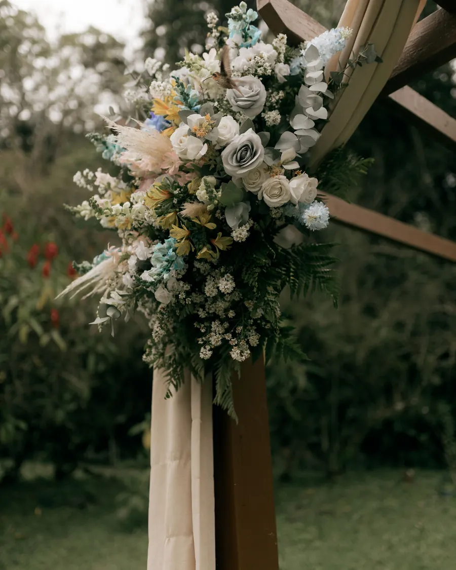 Garden roses and grasses dressing a wooden wedding arch